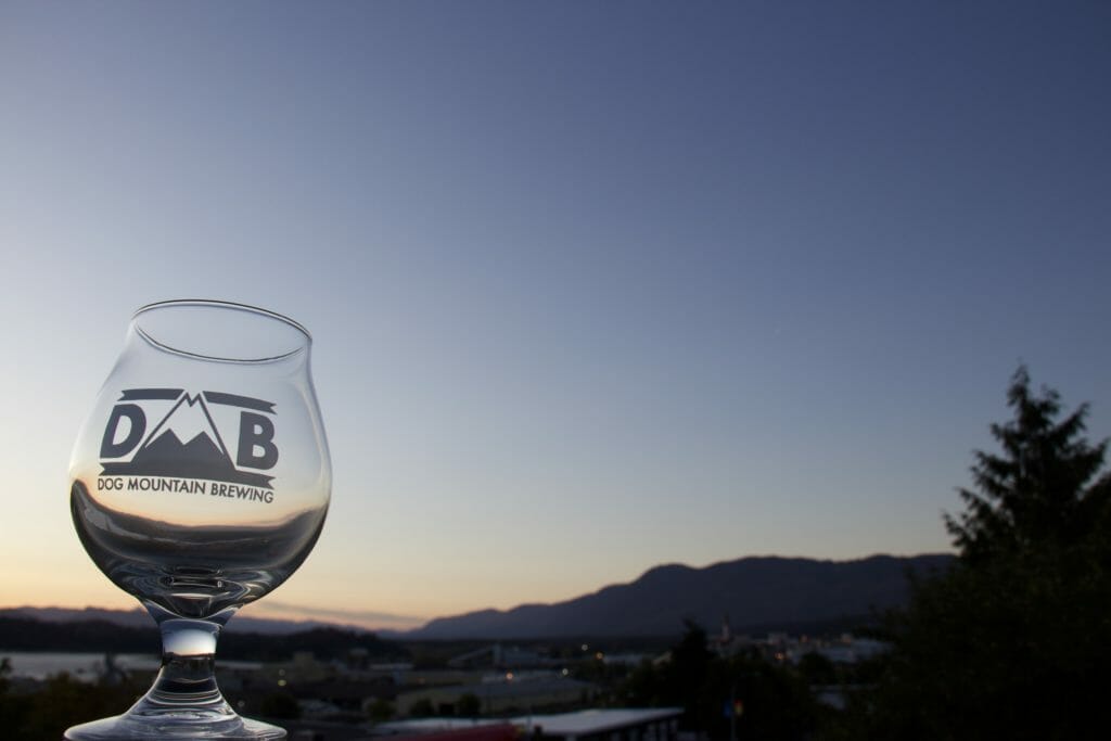 Dog Mountain Brewing glass with Port Alberni's dusk in background