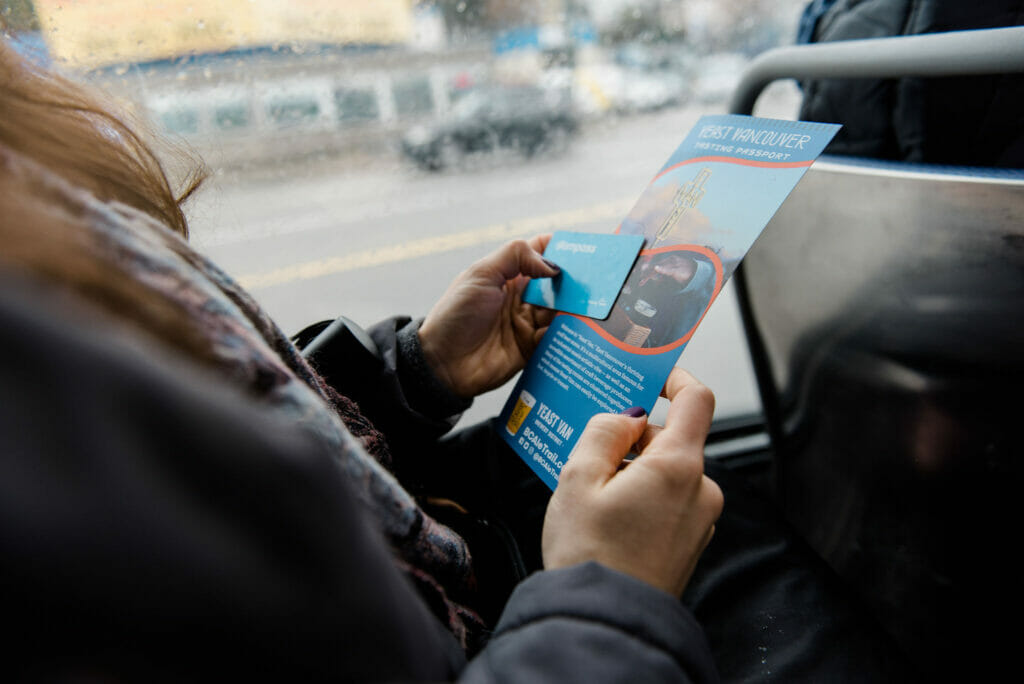 A transit rider with their Dine the Line Tasting Passport and Compass Card